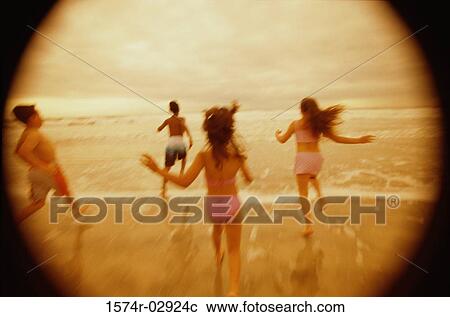 Rear view of a group of children running on the beach View Large Photo Image Stock Image - Rear view of a group of children running on the beach. Fotosearch
