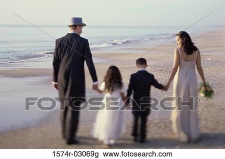 Rear view of a newlywed couple walking on the beach with a flower girl and a ring bearer View Large Photo Image Stock Image - Rear view of a newlywed couple walking on the beach with a flower girl and a ring bearer. Fotosearch