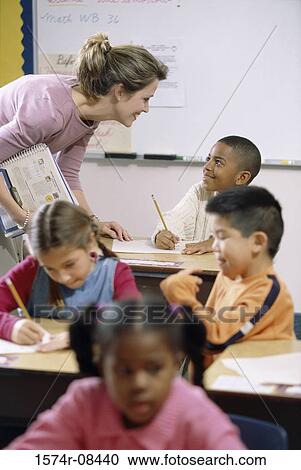 Stock Image - School children in a classroom with a female teacher. Fotosearch