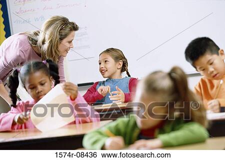 Stock Photograph - School children in a classroom with a female teacher. Fotosearch
