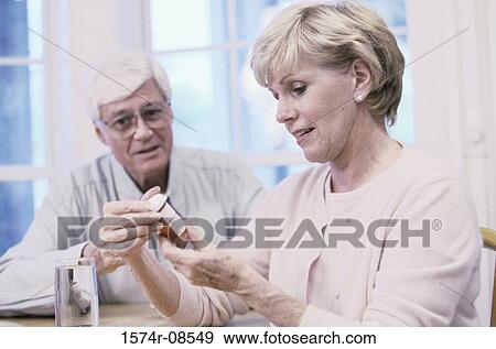 Senior couple looking at a pill bottle View Large Photo Image Stock Photo - Senior couple looking at a pill bottle. Fotosearch