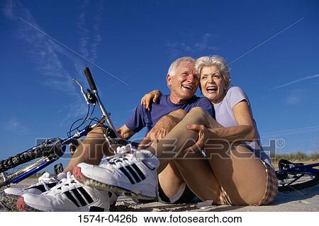 Senior couple sitting on the floor with a bicycle beside them View Large Photo Image Stock Image - Senior couple sitting on the floor with a bicycle beside them. Fotosearch
