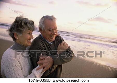 Stock Image - Senior couple standing at the beach. Fotosearch