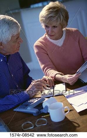 Stock Image - Senior couple writing a check. Fotosearch