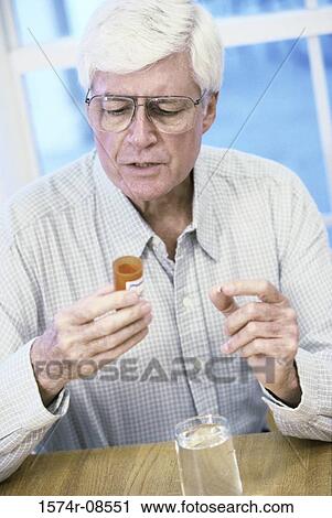 Stock Image - Senior man holding a pill bottle. Fotosearch