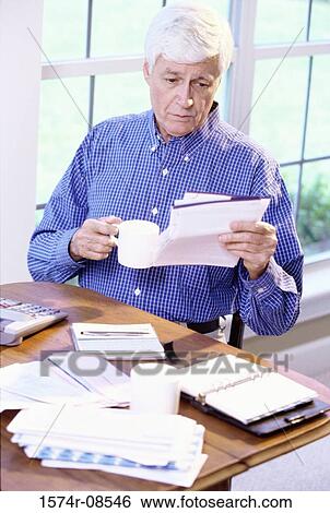 Senior man reading a sheet of paper View Large Photo Image Stock Photograph - Senior man reading a sheet of paper. Fotosearch