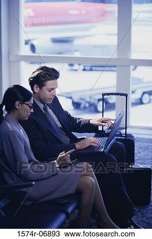 Side profile of a businessman and businesswoman sitting in front of a laptop View Large Photo Image Stock Image - Side profile of a businessman and businesswoman sitting in front of a laptop. Fotosearch
