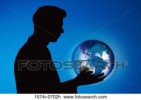 Stock Image - Side profile of a businessman holding a globe. Fotosearch