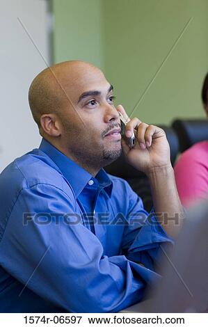 Side profile of a businessman using a mobile phone in an office View Large Photo Image Stock Photo - Side profile of a businessman using a mobile phone in an office. Fotosearch