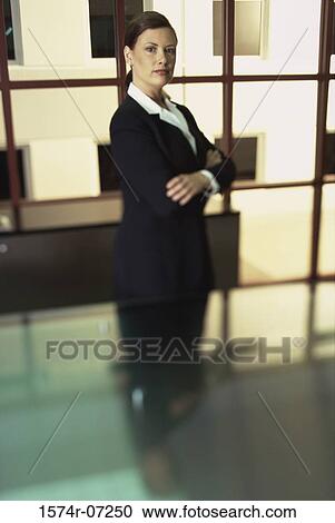 Side profile of a businesswoman standing with her arms folded View Large Photo Image Stock Image - Side profile of a businesswoman standing with her arms folded. Fotosearch