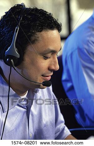 Stock Image - Side profile of a customer service representative wearing a headset. Fotosearch