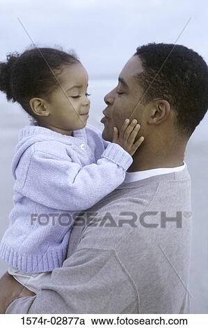 Side profile of a father holding his daughter View Large Photo Image Stock Image - Side profile of a father holding his daughter. Fotosearch