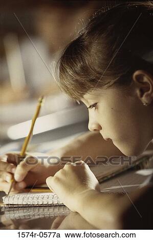 Side profile of a girl writing with a pencil in a book View Large Photo Image Stock Image - Side profile of a girl writing with a pencil in a book. Fotosearch