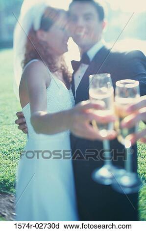 Side profile of a newlywed couple toasting with glasses of champagne View Large Photo Image Stock Image - Side profile of a newlywed couple toasting with glasses of champagne. Fotosearch