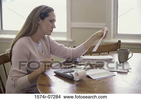 Picture - Side profile of a woman reading a sheet of paper. Fotosearch