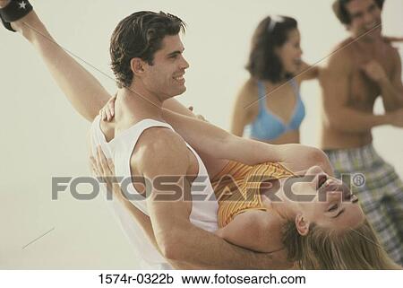 Side profile of a young man carrying a young woman on the beach View Large Photo Image Stock Image - Side profile of a young man carrying a young woman on the beach. Fotosearch