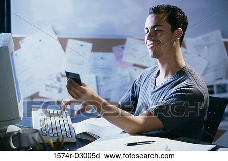 Side profile of a young man working on a computer holding a credit card View Large Photo Image Stock Image - Side profile of a young man working on a computer holding a credit card. Fotosearch