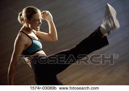 Side profile of a young woman kickboxing View Large Photo Image Stock Image - Side profile of a young woman kickboxing. Fotosearch