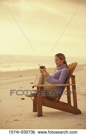 Side profile of a young woman reading a book on the beach View Large Photo Image Stock Image - Side profile of a young woman reading a book on the beach. Fotosearch