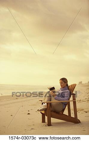 Side profile of a young woman reading a book on the beach View Large Photo Image Stock Image - Side profile of a young woman reading a book on the beach. Fotosearch