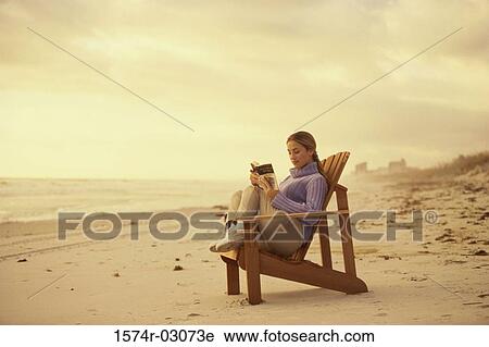 Side profile of a young woman reading a book on the beach View Large Photo Image Stock Image - Side profile of a young woman reading a book on the beach. Fotosearch
