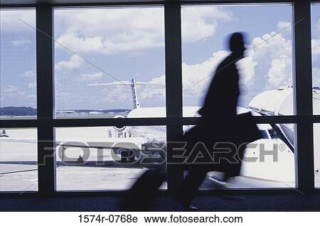 Stock Image - Silhouette of a businessman running at an airport. Fotosearch