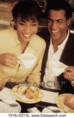 Smiling young couple holding cups of coffee View Large Photo Image Stock Image - Smiling young couple holding cups of coffee. Fotosearch