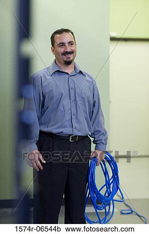 Stock Image - Technician holding computer cables. Fotosearch