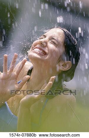 Stock Image - Teenage girl standing in the rain. Fotosearch