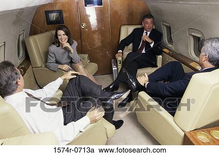 Three businessmen and a businesswoman in an airplane View Large Photo Image Stock Image - Three businessmen and a businesswoman in an airplane. Fotosearch