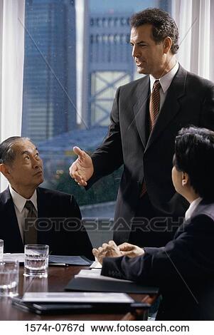 Stock Image - Three businessmen talking in a meeting. Fotosearch