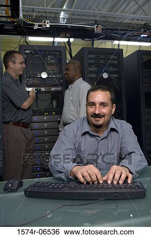 Stock Photograph - Three technicians in a server room. Fotosearch