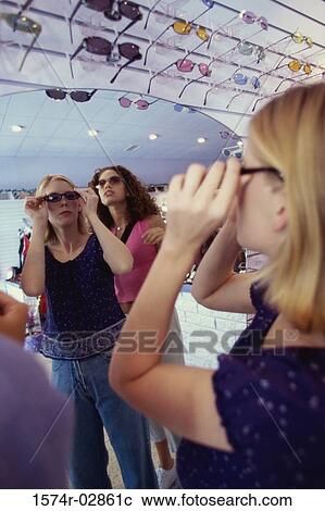 Three young women shopping for sunglasses View Large Photo Image Stock Image - Three young women shopping for sunglasses. Fotosearch