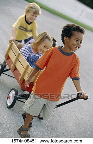 Stock Image - Two boys and a girl playing with a push cart. Fotosearch