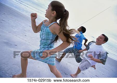 Two boys and a girl running together on the beach View Large Photo Image Stock Image - Two boys and a girl running together on the beach. Fotosearch