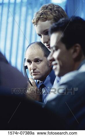 Two businessmen and a businesswoman discussing in an office View Large Photo Image Stock Image - Two businessmen and a businesswoman discussing in an office. Fotosearch