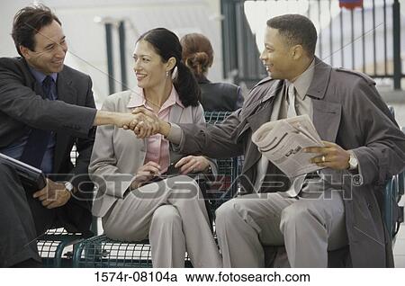 Stock Image - Two businessmen and a businesswoman sitting together. Fotosearch