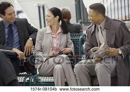 Stock Image - Two businessmen and a businesswoman sitting together. Fotosearch