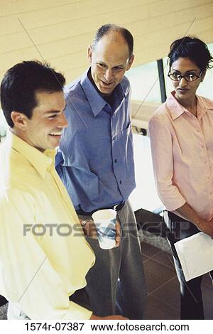 Stock Photo - Two businessmen and a businesswoman standing together. Fotosearch