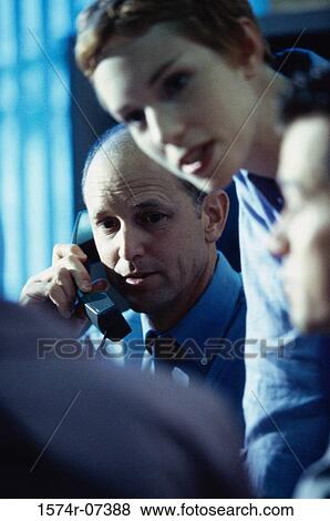 Stock Photo - Two businessmen and a businesswoman discussing in an office. Fotosearch