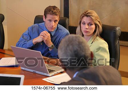 Two businessmen and a businesswoman sitting in a conference room View Large Photo Image Stock Photography - Two businessmen and a businesswoman sitting in a conference room. Fotosearch
