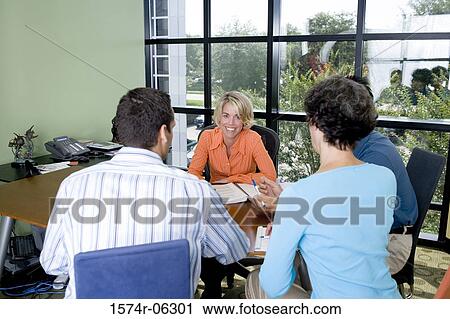 Two businessmen and two businesswomen sitting in a conference room View Large Photo Image Stock Image - Two businessmen and two businesswomen sitting in a conference room. Fotosearch