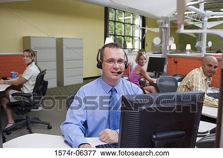 Stock Photo - Two businessmen and two businesswomen sitting in an office. Fotosearch