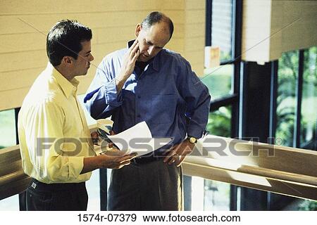 Two businessmen discussing a report View Large Photo Image Stock Photo - Two businessmen discussing a report. Fotosearch