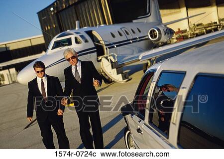 Two businessmen walking in an airport View Large Photo Image Stock Image - Two businessmen walking in an airport. Fotosearch