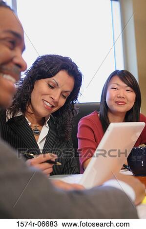 Two businesswomen and a businessman sitting in a conference room View Large Photo Image Stock Image - Two businesswomen and a businessman sitting in a conference room. Fotosearch