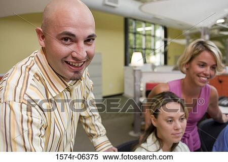 Two businesswomen and a businessman sitting in an office View Large Photo Image Stock Photography - Two businesswomen and a businessman sitting in an office. Fotosearch