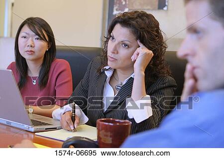 Two businesswomen and a businessman sitting in a conference room View Large Photo Image Stock Photography - Two businesswomen and a businessman sitting in a conference room. Fotosearch