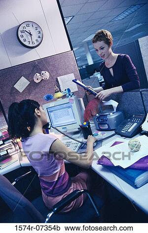 Stock Image - Two businesswomen in an office talking. Fotosearch