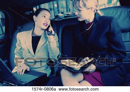 Two businesswomen sitting in a car View Large Photo Image Stock Image - Two businesswomen sitting in a car. Fotosearch